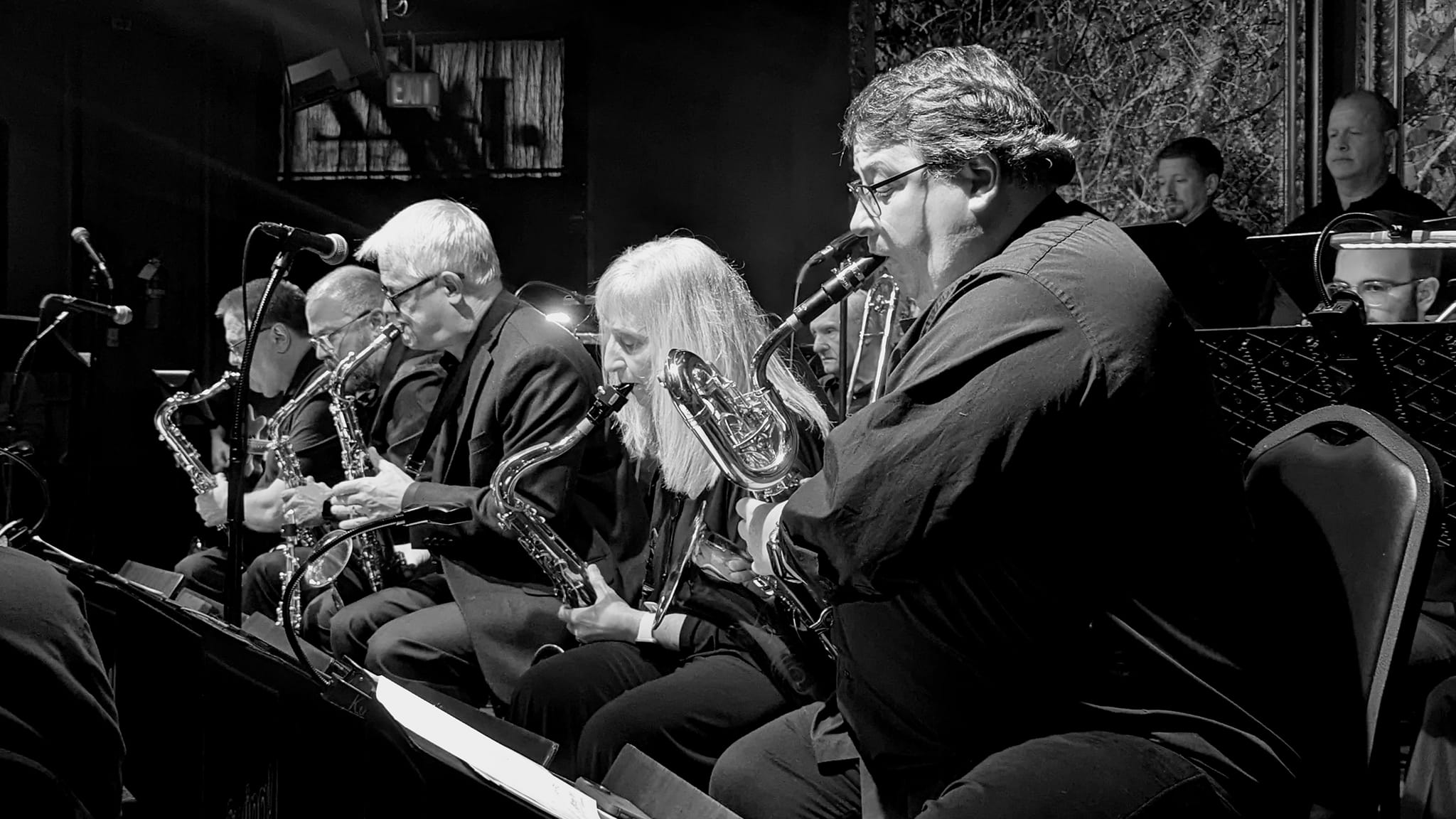 Black and white photograph of a jazz big band saxophone section performing live