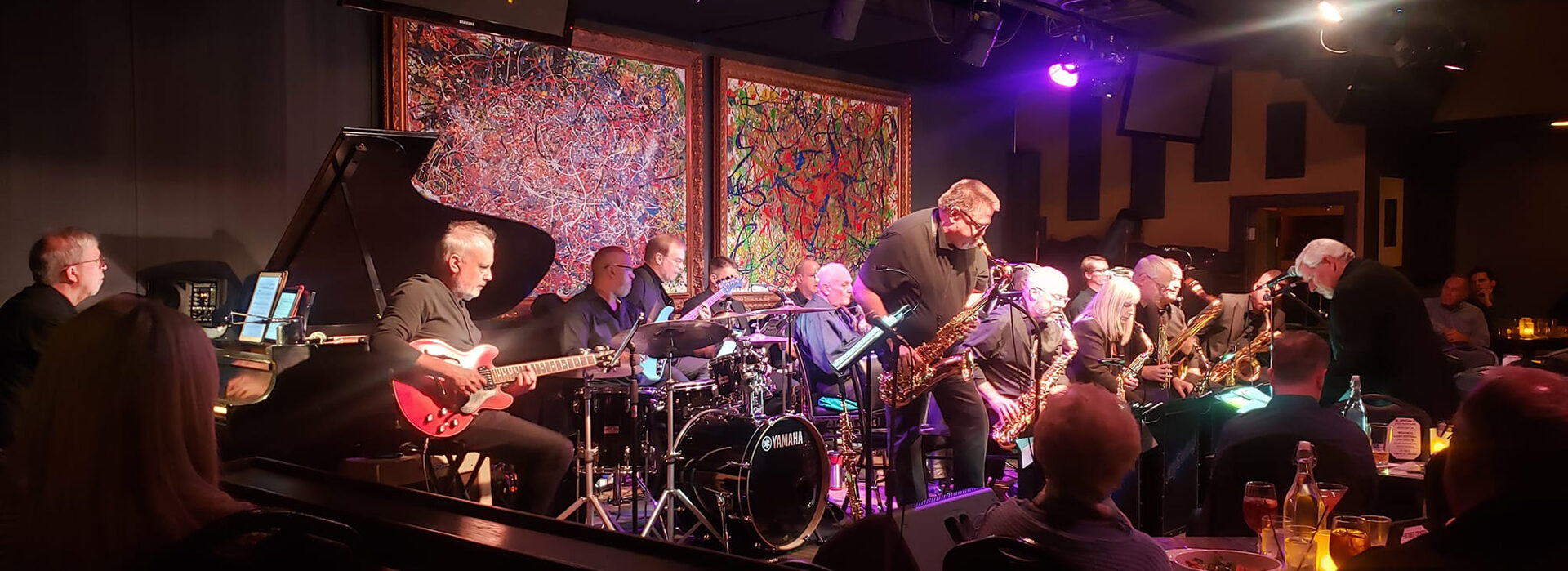 The JoySwing big band performing on a dimly lit stage