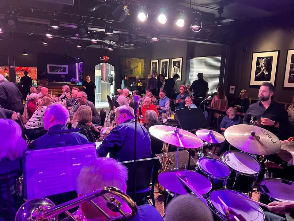 JoySwing drum kit and audience under purple stage lights